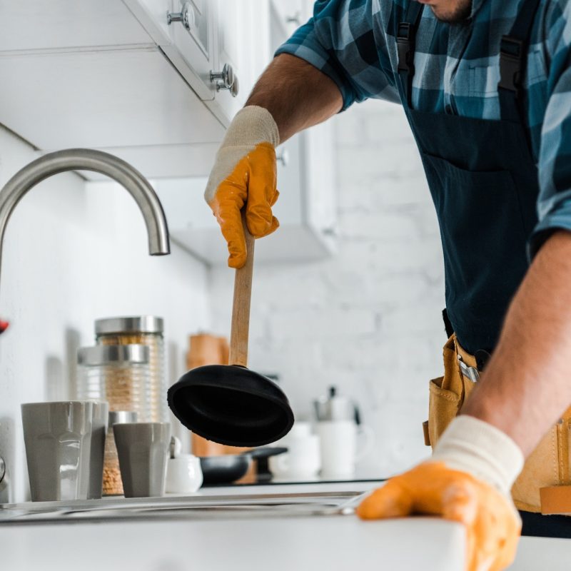 cropped-view-of-repairman-holding-plunger-in-kitchen.jpg