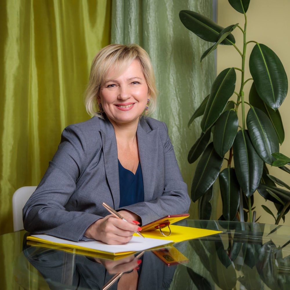 an-attractive-middle-aged-woman-director-is-sitting-at-a-table-in-the-office-filling-out-document.jpg