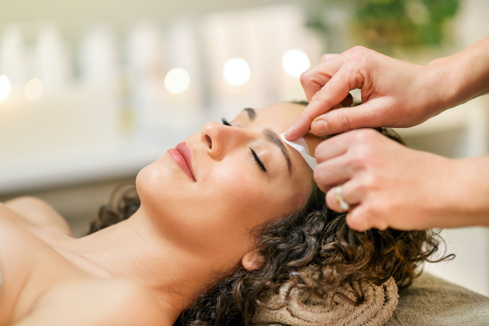 master-waxing-eyebrow-of-relaxed-client-in-beauty-studio.jpg
