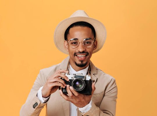 black-man-in-hat-and-glasses-holding-retro-camera-2021-09-03-01-24-36-utc-e1661912402101.jpg