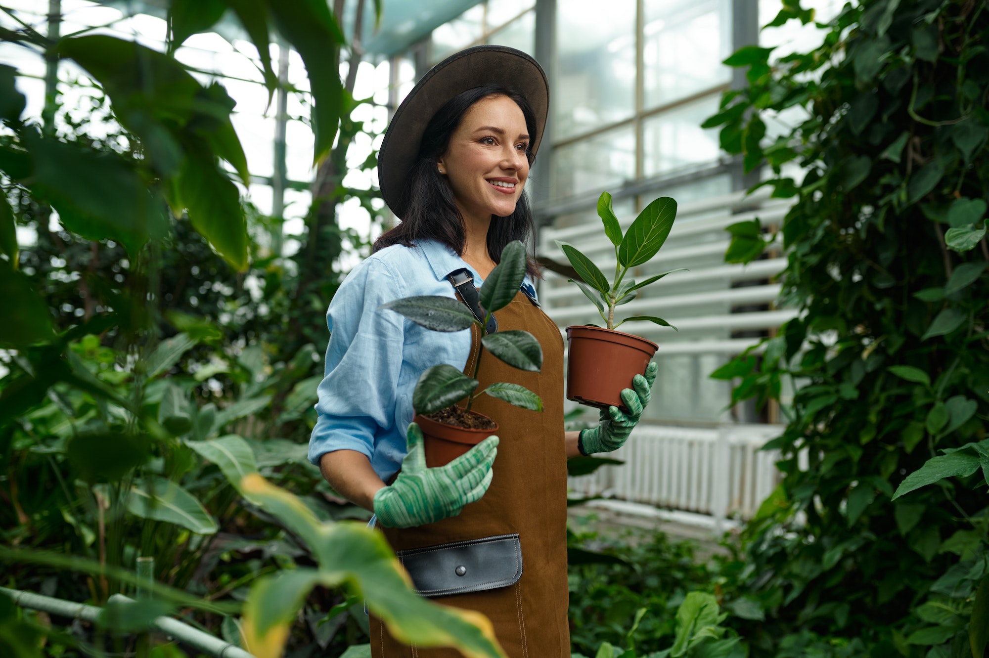 happy-smiling-woman-gardener-planting-flower-in-greenhouse-garden.jpg
