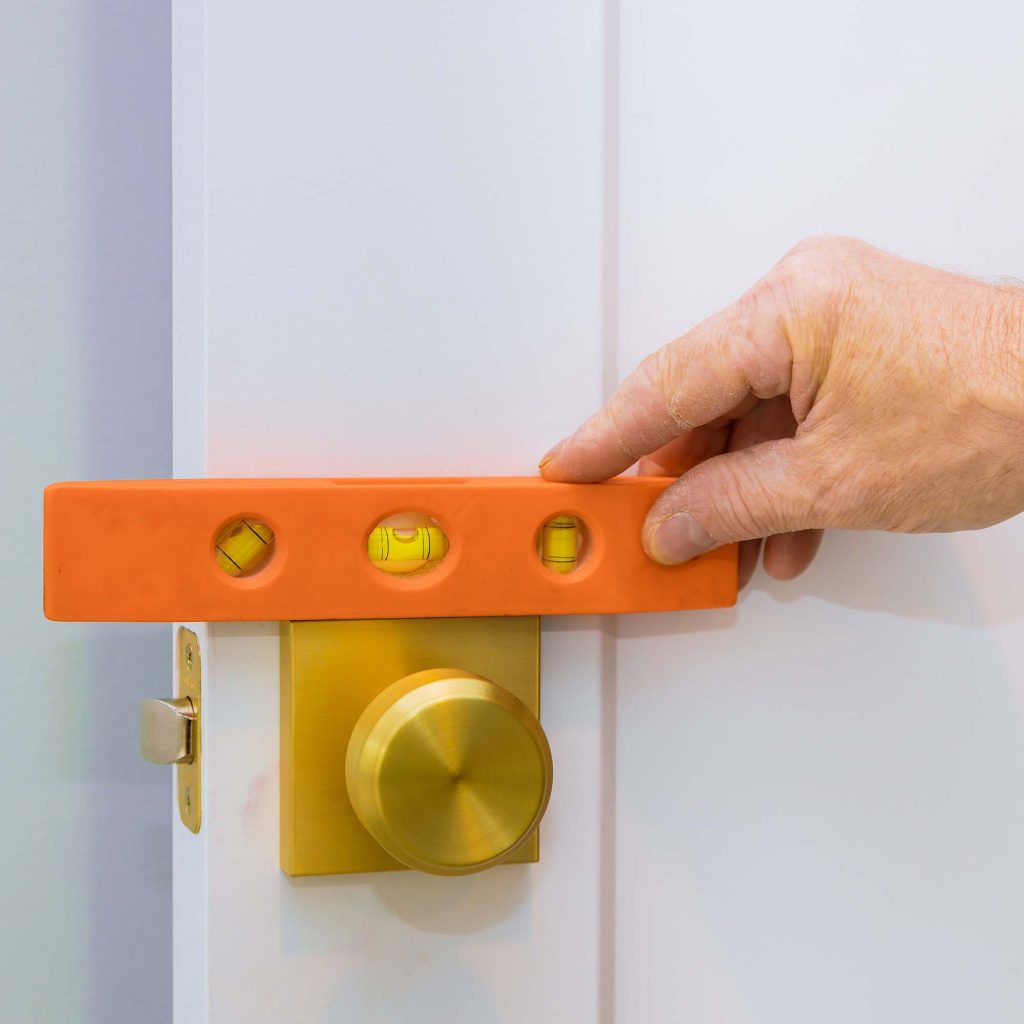 male-carpenter-fixing-lock-in-door-with-home-hand-VY3HHLQ-1.jpg