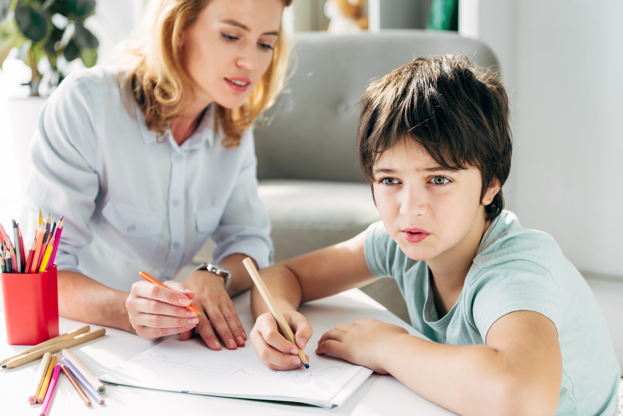 kid-with-dyslexia-and-child-psychologist-sitting-at-table-and-holding-pencils.jpg