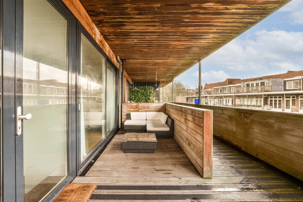 a-balcony-with-a-wooden-deck-and-a-glass-door-GUFY9D5.jpg