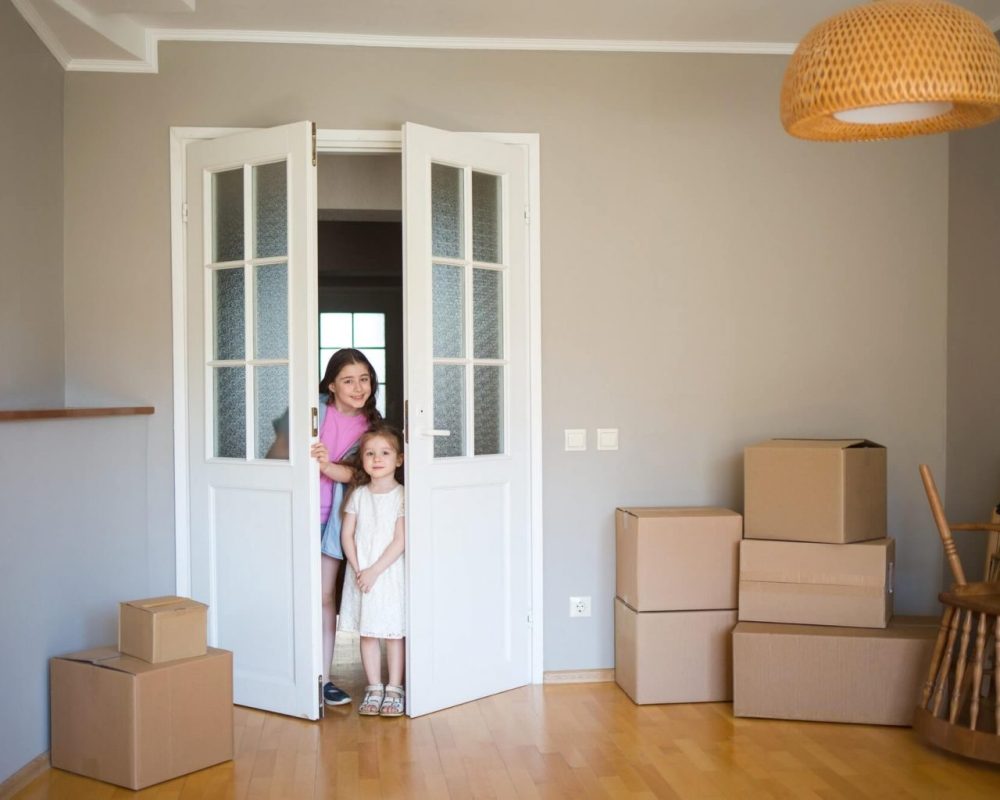 children-look-into-its-new-home-moving-to-apartment-boxes-in-house-1-1-1536x1024