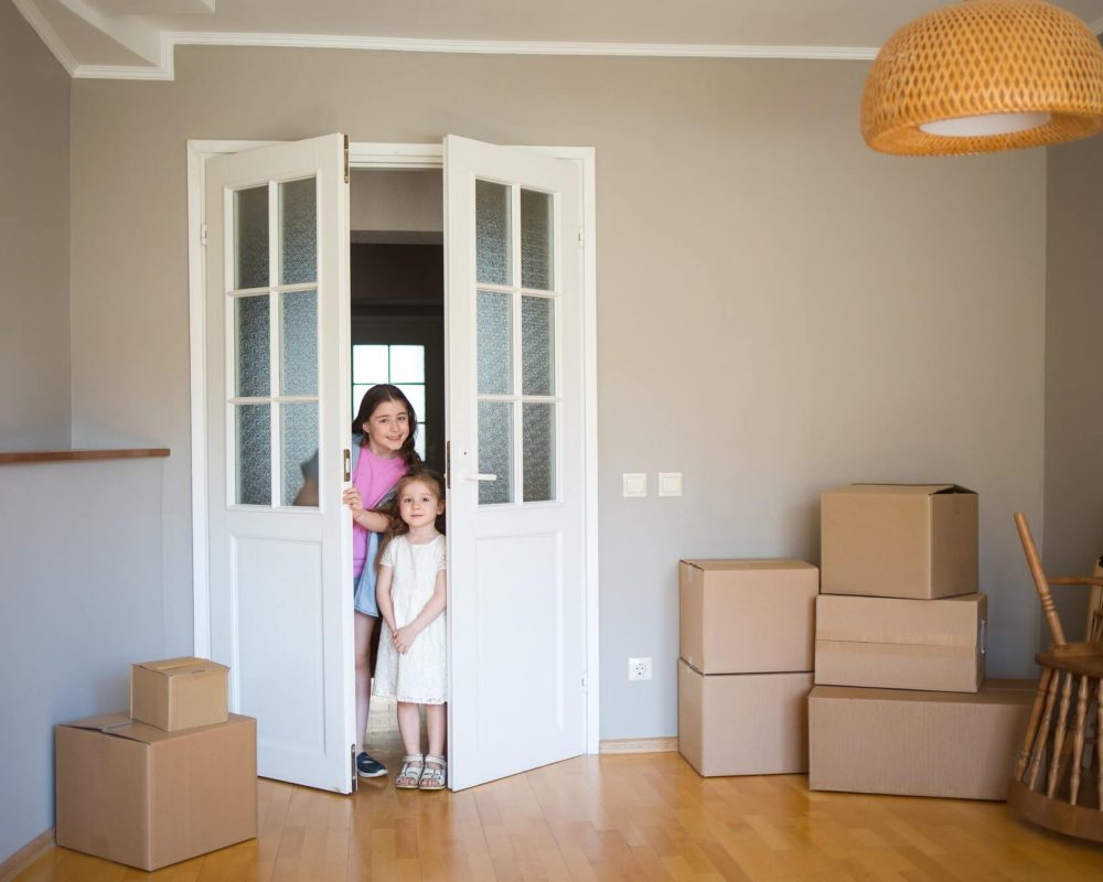 children-look-into-its-new-home-moving-to-apartment-boxes-in-house-1-1