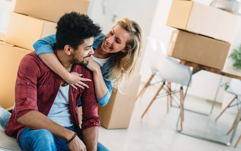 young-couple-unpacking-cardboard-boxes-at-new-home-KFP6NHQ.jpg