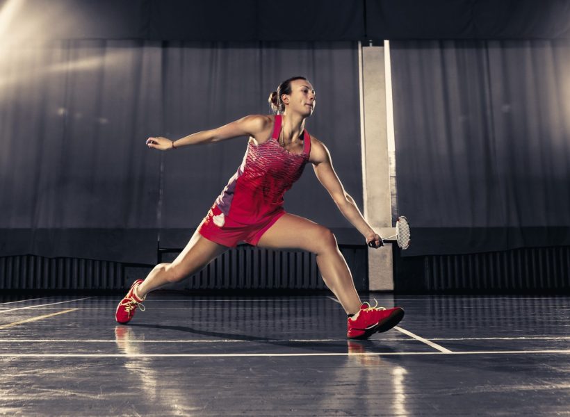 young-woman-playing-badminton-at-gym-e1657617468257.jpg