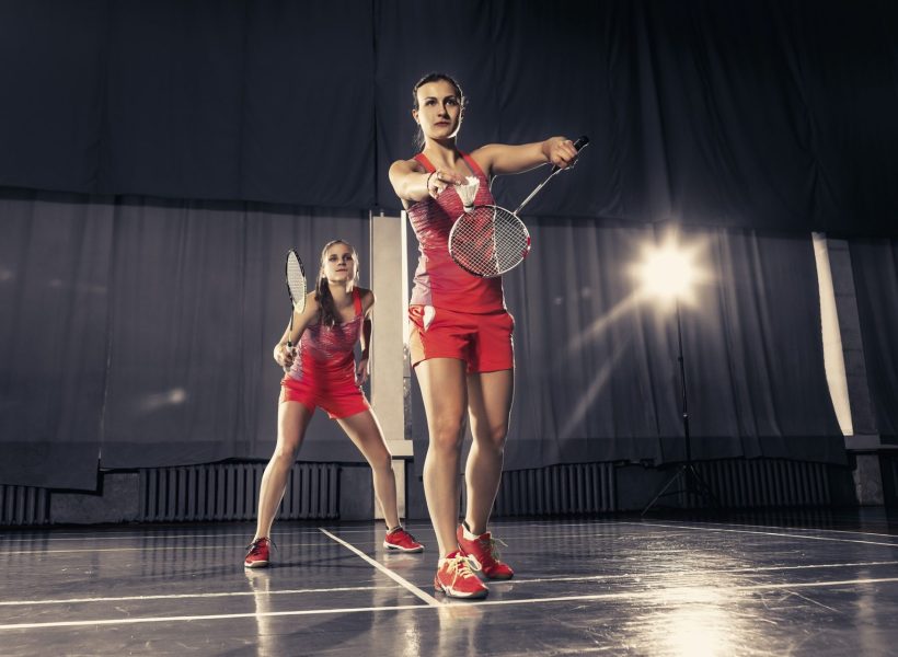 young-women-playing-badminton-at-gym-1-e1657173703217.jpg